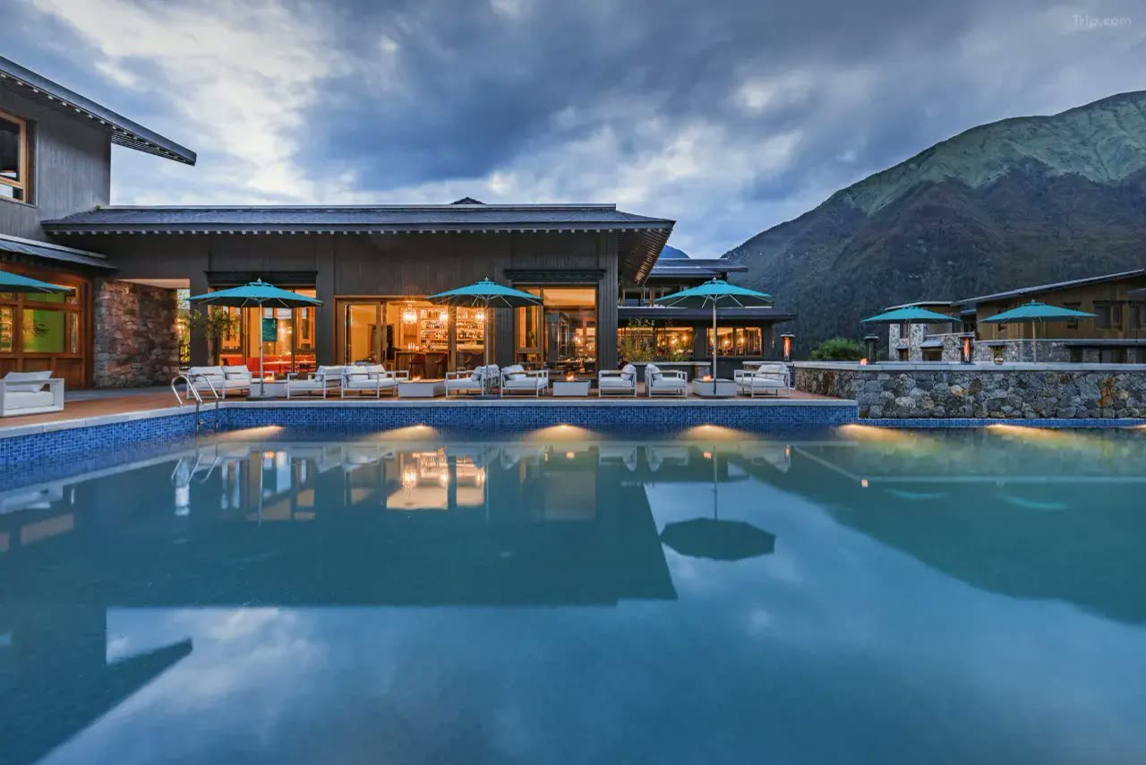 Outdoor pool and terrace at dusk at Songtsam Basong Tso Lodge