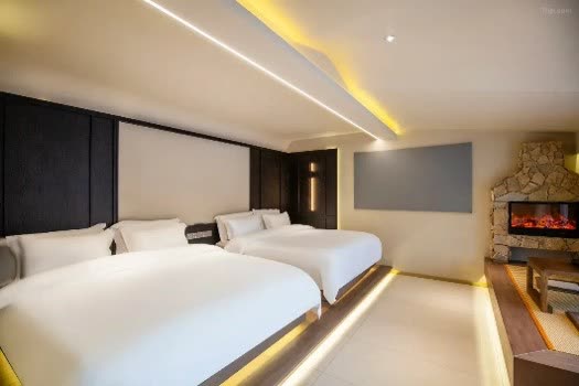 Twin guestroom with fireplace and warm lighting at Lanting Snow Hotel