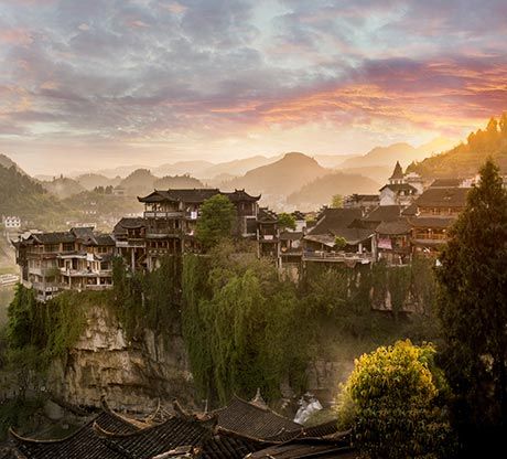 Furong Tujia village perched above its cascading waterfall at sunset