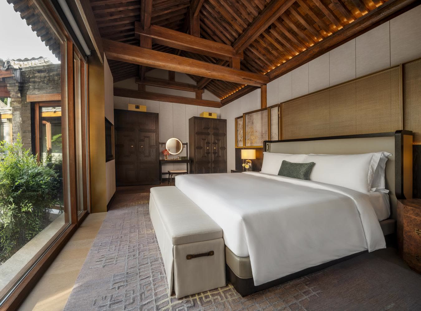 Grand Residential Courtyard bedroom with exposed timber roof at Mandarin Oriental Qianmen, Beijing