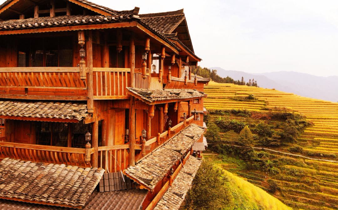 Timber exterior of Longji One Art Hotel above the golden Longsheng rice terraces