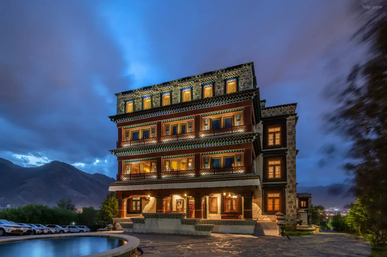 Songtsam Lhasa Linka lit at dusk with the mountains behind