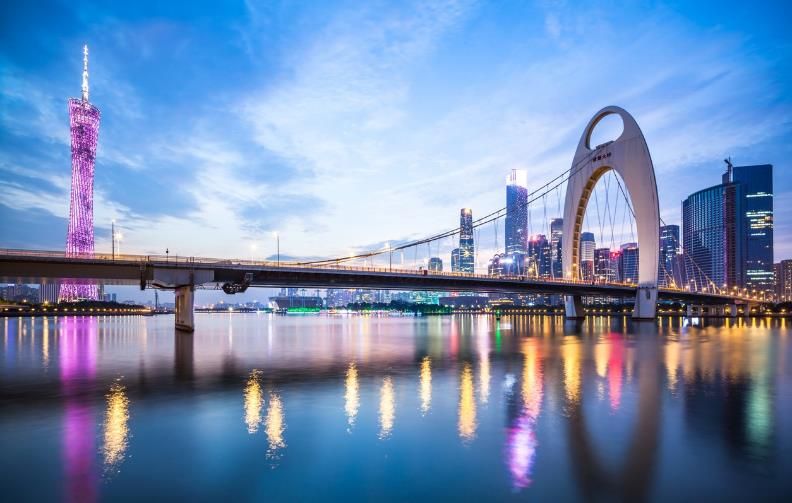 Canton Tower and Liede Bridge lit up over the Pearl River at dusk
