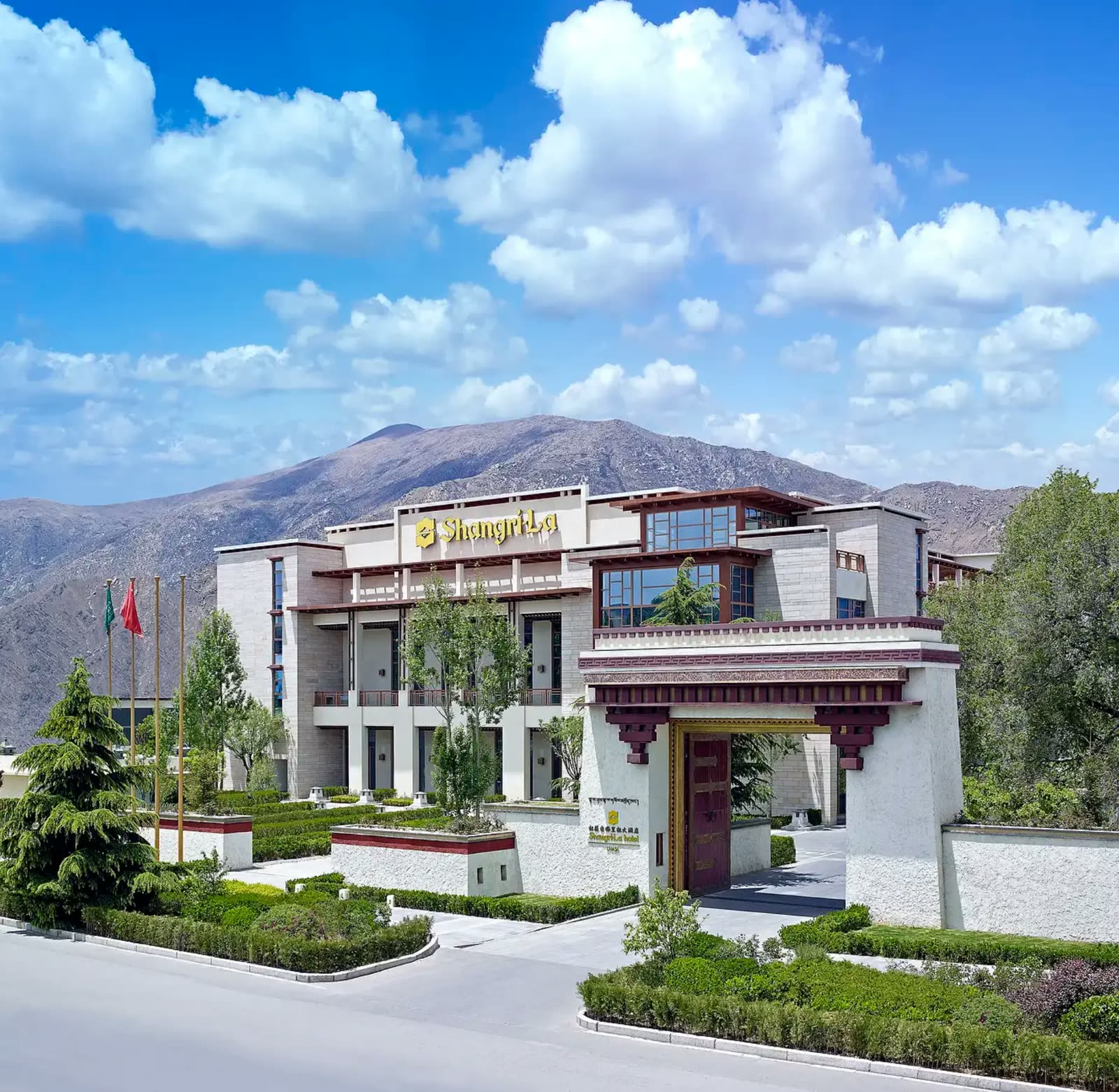 Tibetan-styled facade of Shangri-La Hotel Lhasa below bare mountains