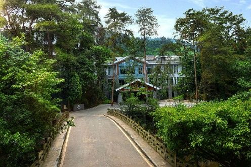 Hong Zhu Shan Hotel building among trees at the foot of Mount Emei