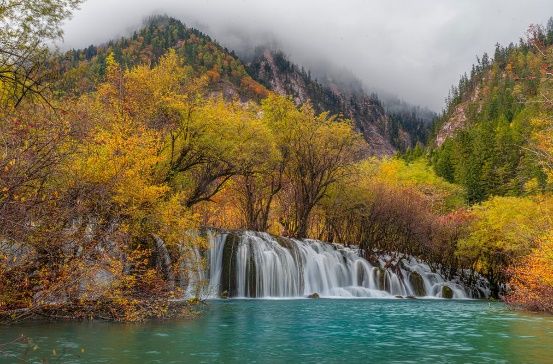 Layered waterfall running through autumn foliage in Jiuzhaigou